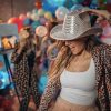 A blonde woman in a cowboy hat dancing