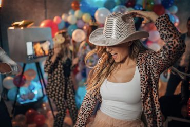A blonde woman in a cowboy hat dancing