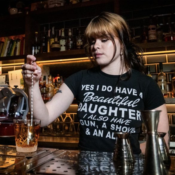 young female bartender mixing drink